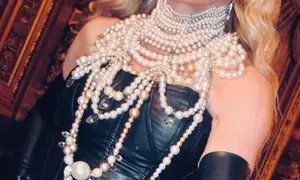 Madonna pairs black corset with pearl necklaces, fishnets in new pictures